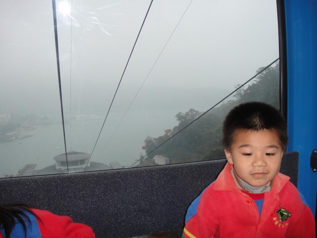 外籍新娘生的新臺灣之子<br />已經搭兩趟纜車,一臉無奈的樣子<br />其姊則依偎在媽媽懷裡撒嬌,笑得很高興